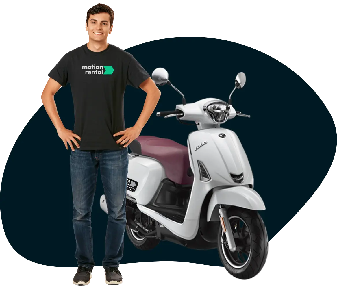 a boy wearing motion rental shirt in front of a scooter